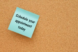 bulletin board with post it note saying schedule your appointment today